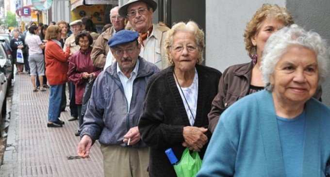 Personas mayores haciendo fila en una calle